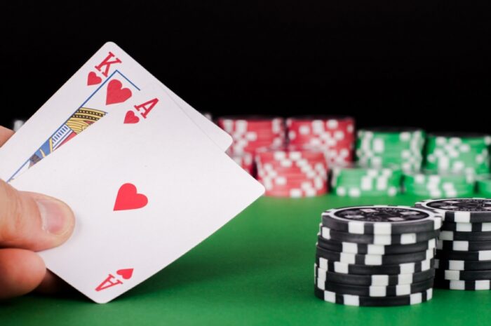 Hand holding ace and king of hearts