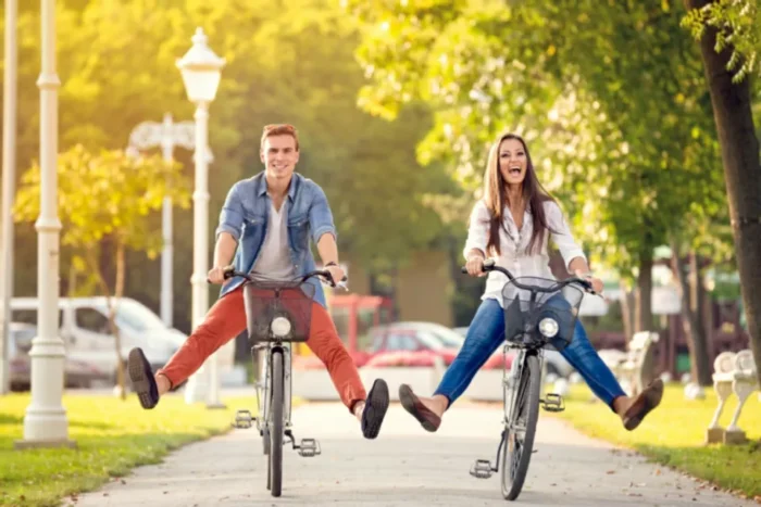 happy young adults riding bikes in the summer time