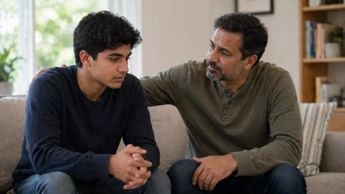 Father talking to young adult son in lounge